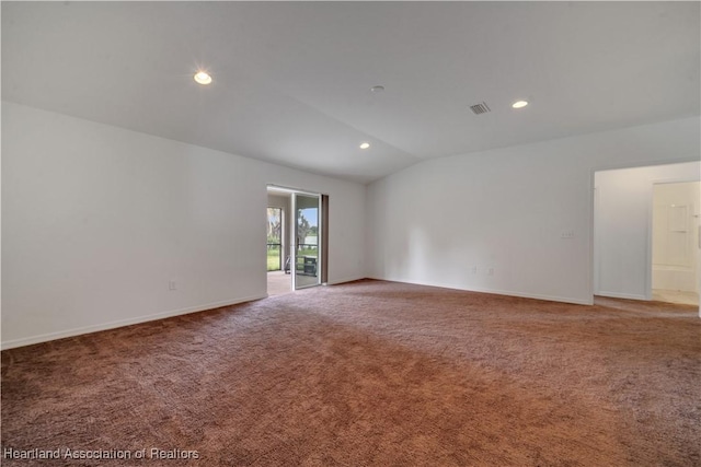 spare room featuring carpet and vaulted ceiling