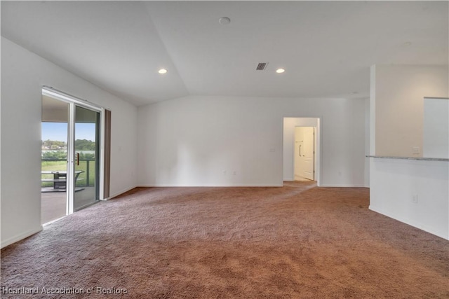 spare room featuring light carpet and vaulted ceiling