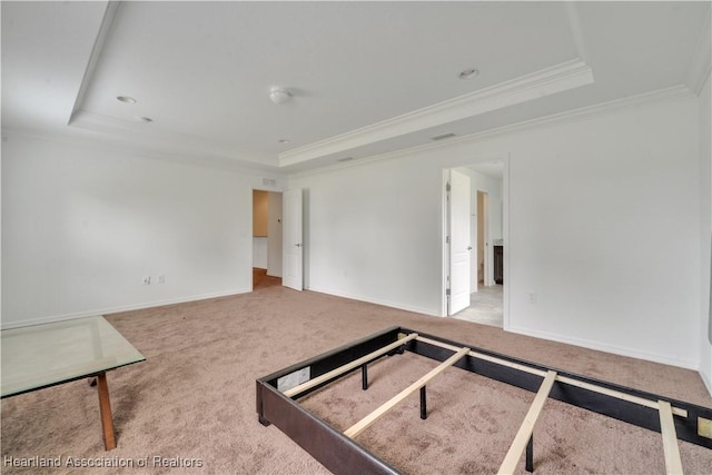 unfurnished room with carpet, a raised ceiling, and crown molding