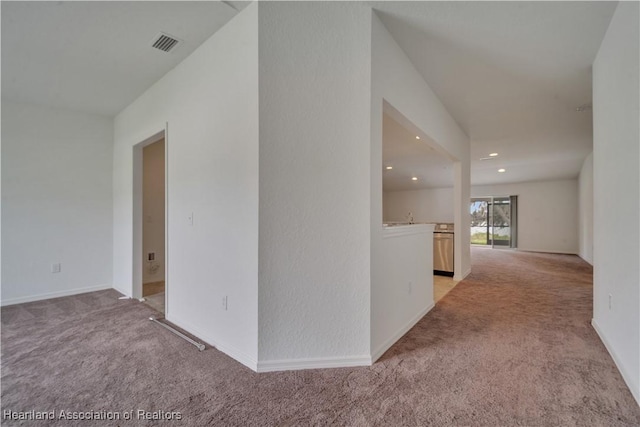 hall with light colored carpet