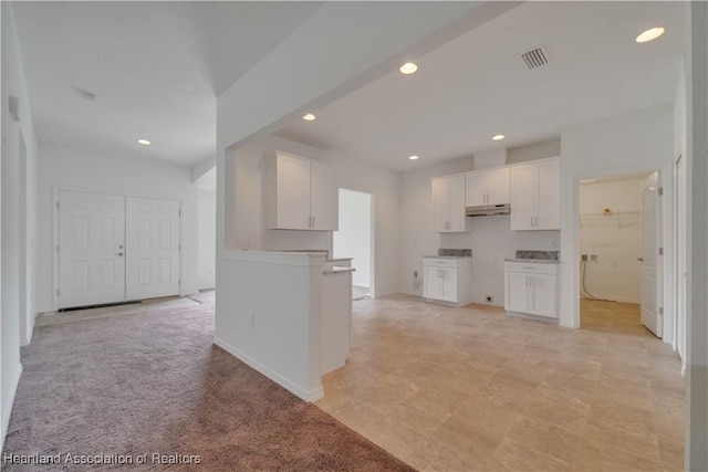 kitchen with white cabinets and light colored carpet