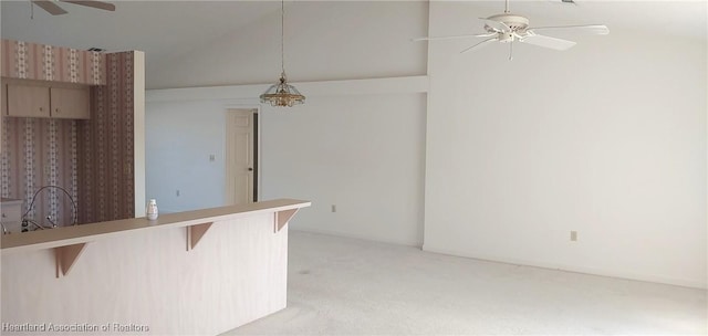 kitchen featuring a breakfast bar, light carpet, kitchen peninsula, pendant lighting, and ceiling fan