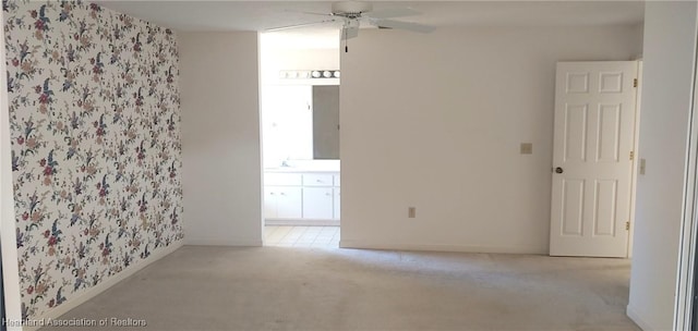 empty room with ceiling fan, light colored carpet, and sink