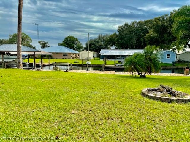 view of yard with a water view and a boat dock