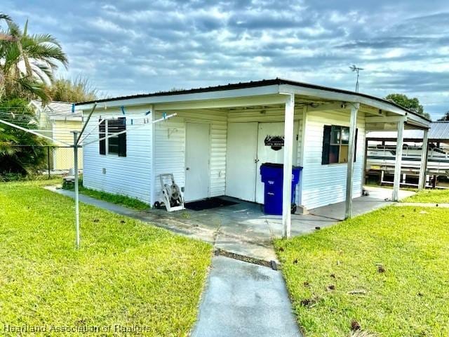 exterior space with a lawn and a carport