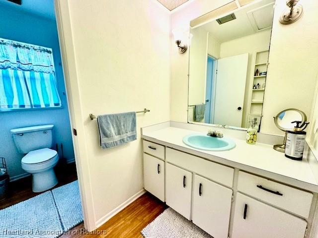 bathroom with vanity, hardwood / wood-style flooring, and toilet