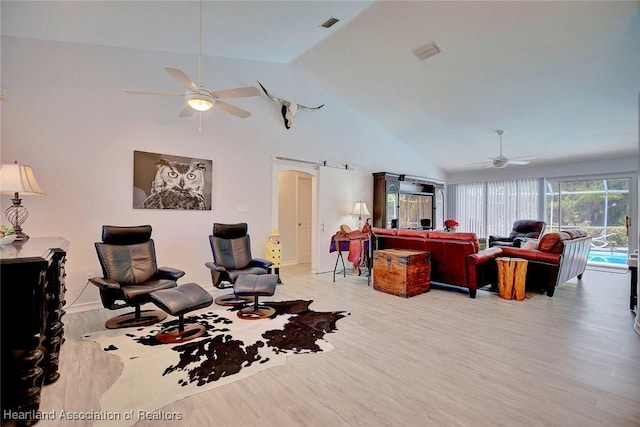 sitting room with ceiling fan, vaulted ceiling, and light wood-type flooring