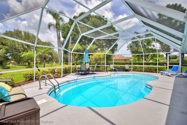 view of swimming pool with glass enclosure and a patio area