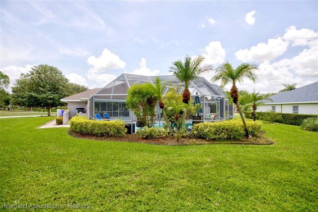 back of house featuring a yard and a lanai