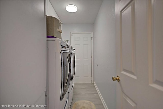 laundry room featuring independent washer and dryer and light hardwood / wood-style floors