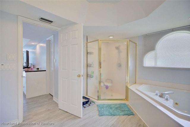 bathroom with plus walk in shower and hardwood / wood-style flooring