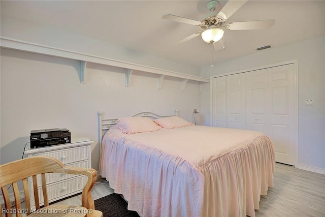 bedroom with ceiling fan, light hardwood / wood-style floors, and a closet