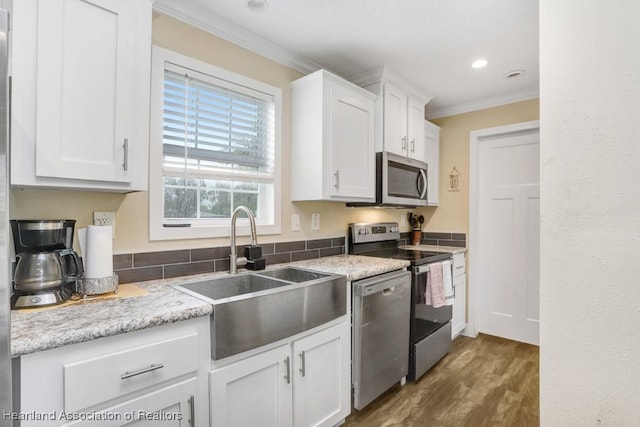 317 Old Bradenton Rd, Wauchula, FL 33873 - kitchen with a sink, appliances with stainless steel finishes, crown molding, white cabinets, and wood finished floors