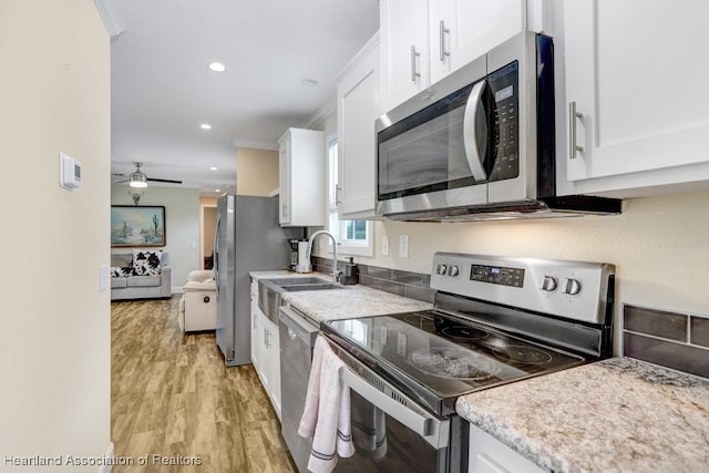 317 Old Bradenton Rd, Wauchula, FL 33873 - kitchen with appliances with stainless steel finishes, white cabinets, light wood-style flooring, recessed lighting, and light countertops