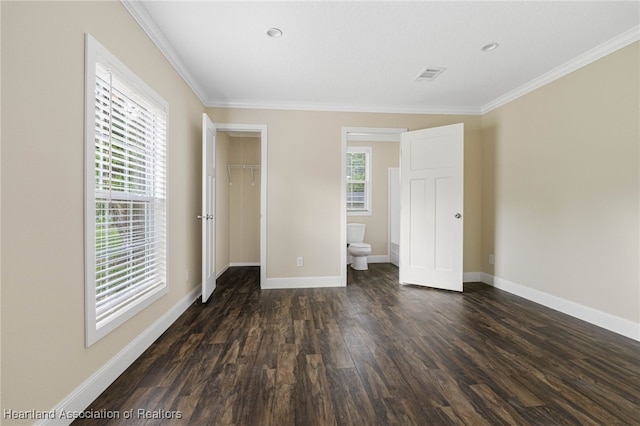 317 Old Bradenton Rd, Wauchula, FL 33873 - unfurnished bedroom with dark wood-type flooring, a spacious closet, crown molding, baseboards, and a closet
