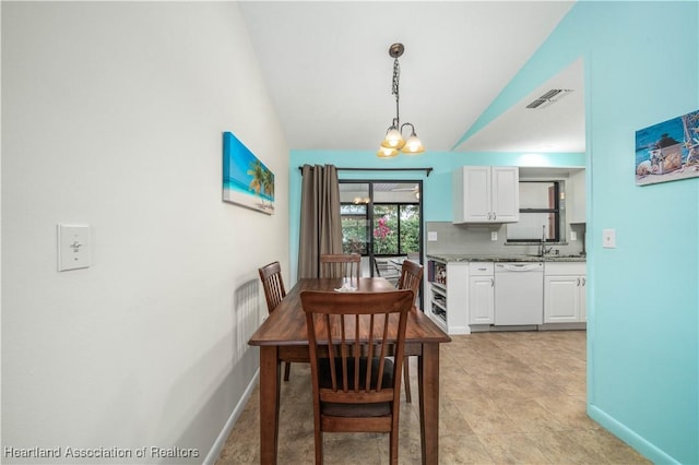 dining area featuring an inviting chandelier, sink, and vaulted ceiling