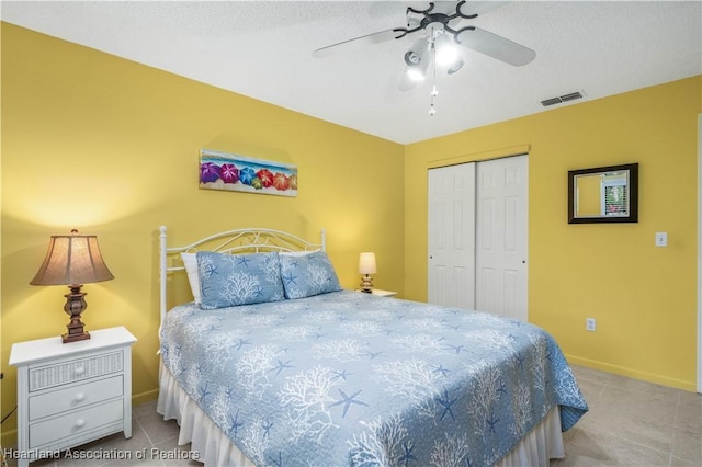 bedroom featuring ceiling fan, a textured ceiling, and a closet