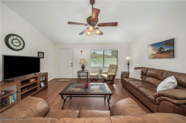 living room with ceiling fan, dark hardwood / wood-style flooring, lofted ceiling, and a textured ceiling