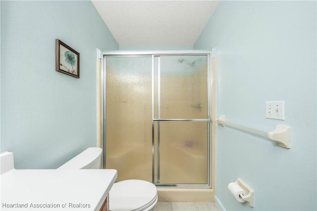 bathroom featuring an enclosed shower, vanity, a textured ceiling, tile patterned flooring, and toilet