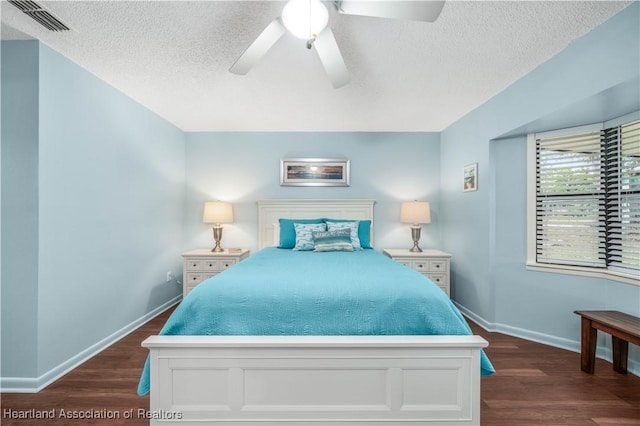 bedroom with ceiling fan, dark hardwood / wood-style floors, and a textured ceiling