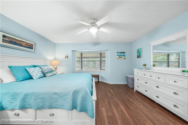 bedroom with ceiling fan, dark wood-type flooring, and a textured ceiling