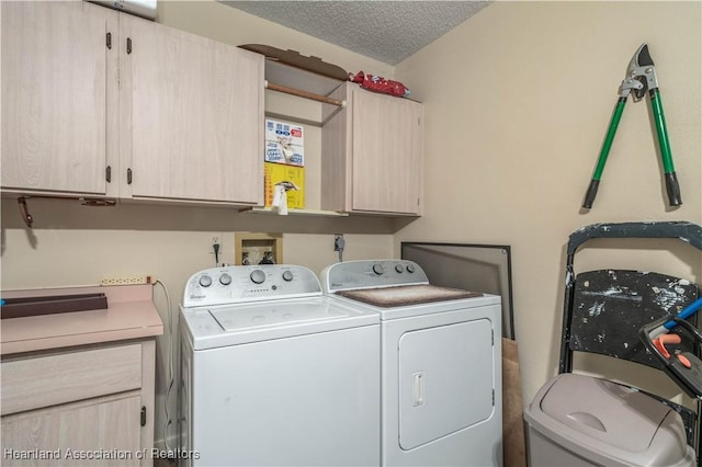 washroom with washer and clothes dryer, cabinets, and a textured ceiling