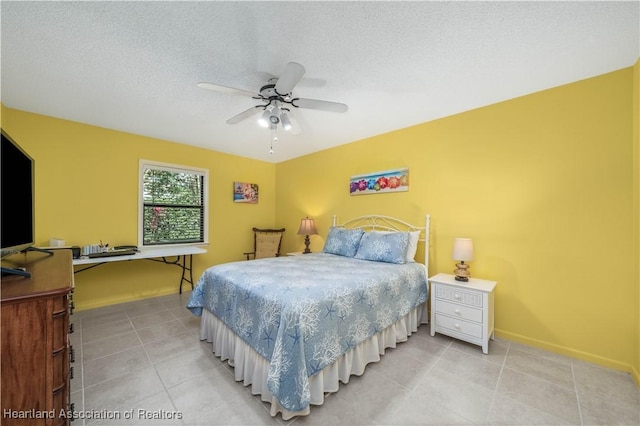 bedroom with ceiling fan and a textured ceiling