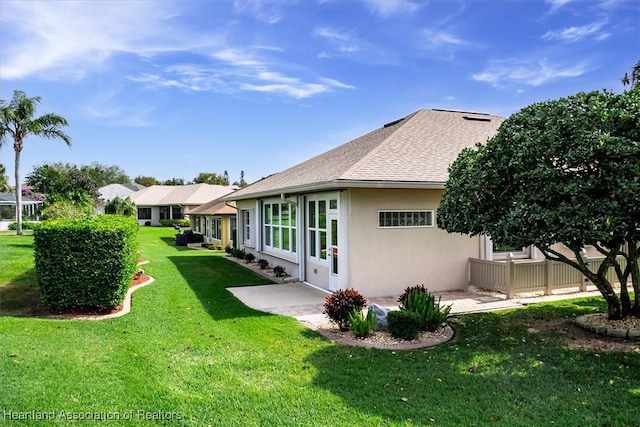rear view of property featuring a lawn
