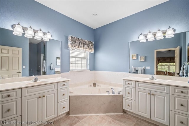 bathroom featuring a bathing tub, vanity, and tile patterned flooring