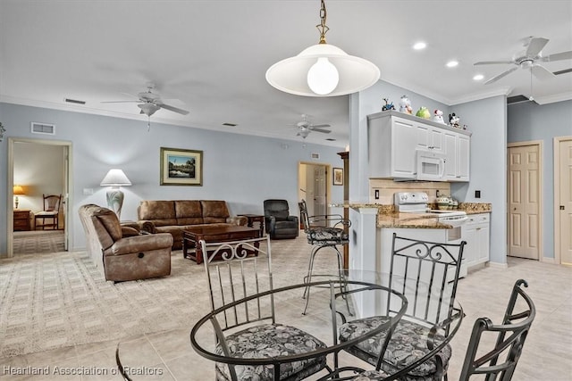 dining room with light tile patterned flooring, ceiling fan, and crown molding