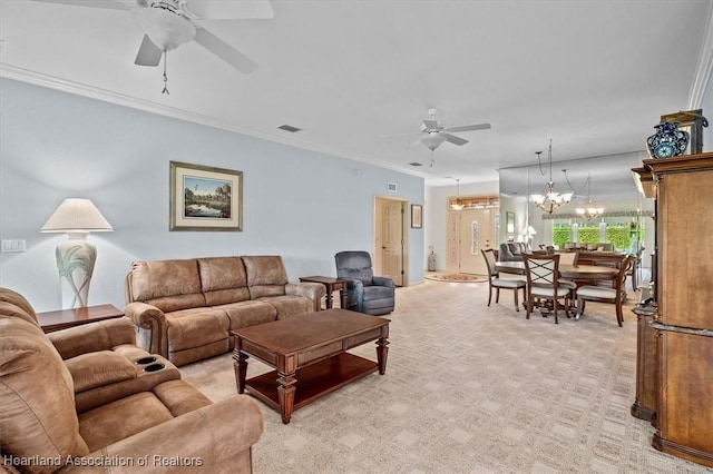 living room with ceiling fan with notable chandelier, ornamental molding, and light carpet