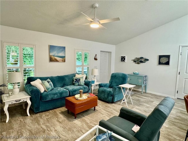 living room with ceiling fan, a textured ceiling, and light hardwood / wood-style flooring