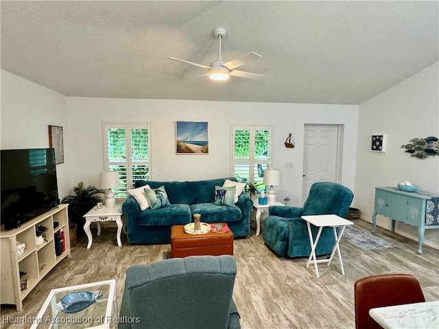 living room featuring ceiling fan, wood-type flooring, and a textured ceiling