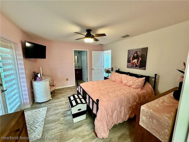 bedroom with hardwood / wood-style floors, ceiling fan, and ensuite bathroom