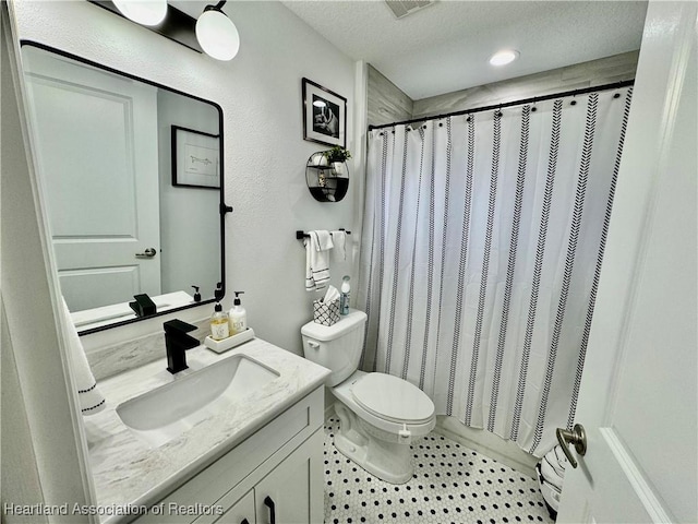 bathroom with walk in shower, vanity, a textured ceiling, and toilet