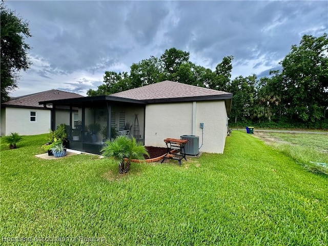 back of property with a sunroom and a yard