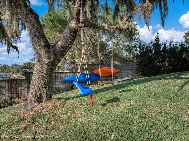 view of play area featuring a yard, a trampoline, and fence