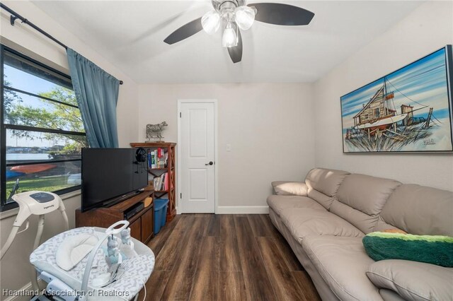 living area with dark wood finished floors, baseboards, and ceiling fan