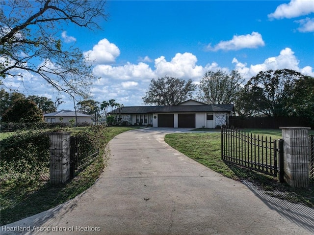 view of front facade featuring a fenced front yard, a front yard, driveway, and an attached garage