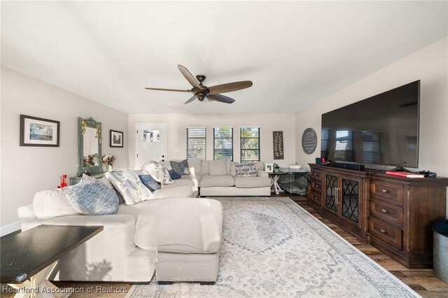 living room featuring a ceiling fan and wood finished floors