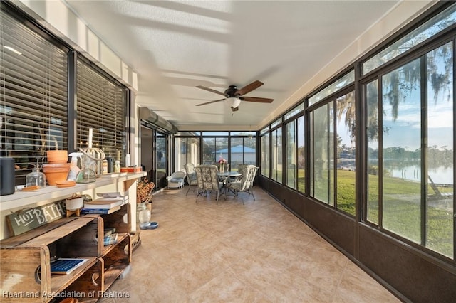 sunroom featuring a water view, a healthy amount of sunlight, and ceiling fan