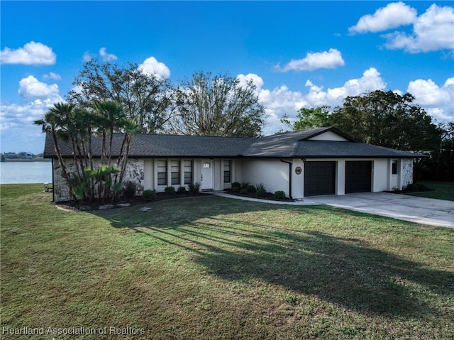 ranch-style house with stucco siding, a water view, an attached garage, a front yard, and driveway