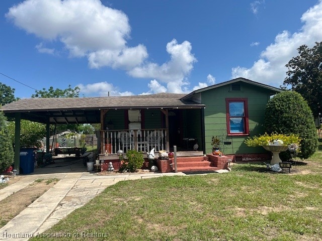 410 Walnut St, Sebring, FL 33870 - view of front of house featuring a front lawn, a carport, concrete driveway, and a porch