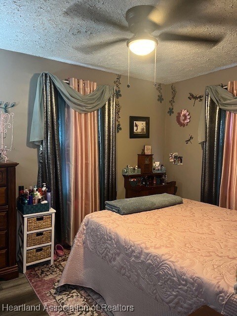 410 Walnut St, Sebring, FL 33870 - bedroom featuring wood finished floors, a textured ceiling, and ceiling fan