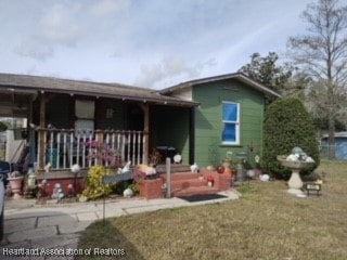 view of front of house with covered porch and a front yard