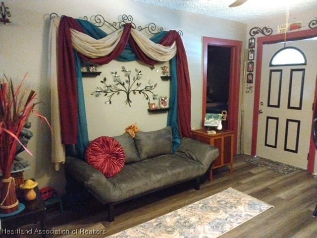 interior space featuring dark hardwood / wood-style flooring, ceiling fan, and a textured ceiling