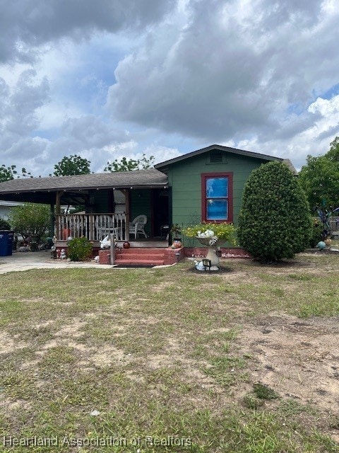 410 Walnut St, Sebring, FL 33870 - view of front of house with a porch and a front lawn