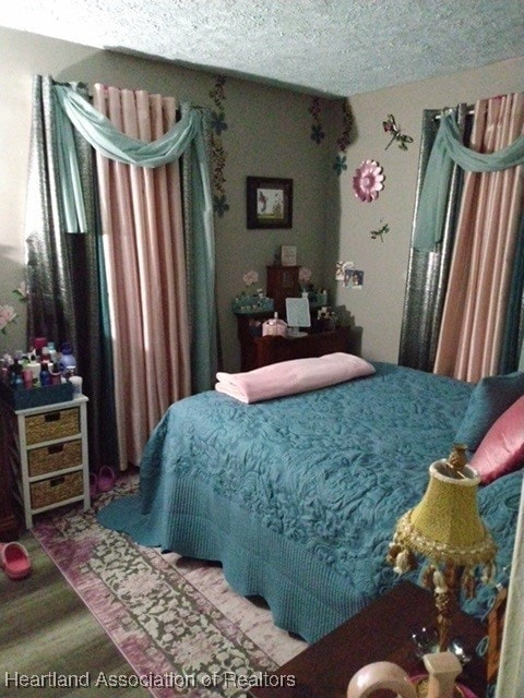 bedroom with hardwood / wood-style floors and a textured ceiling