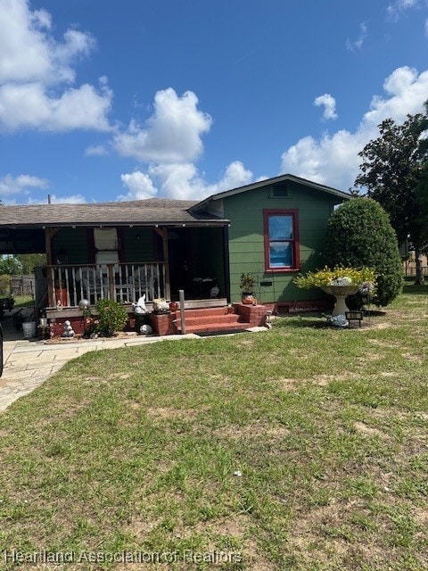 410 Walnut St, Sebring, FL 33870 - rear view of house featuring a lawn and covered porch