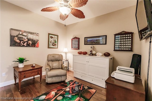 living area with ceiling fan and dark hardwood / wood-style flooring